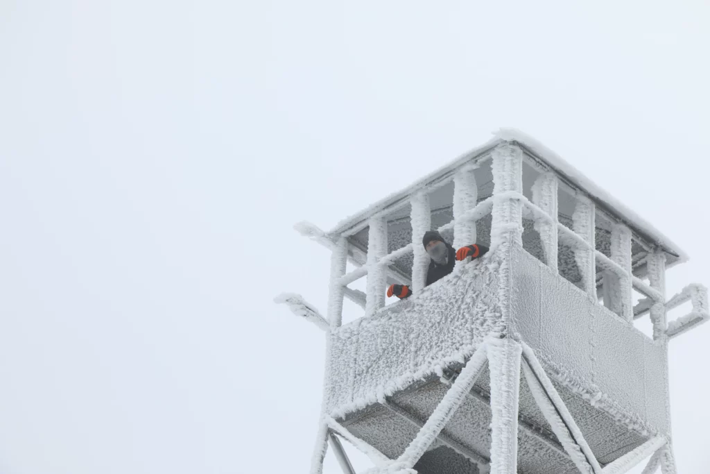 Kevin leaning out of the frozen Tower on Blue Mountain.