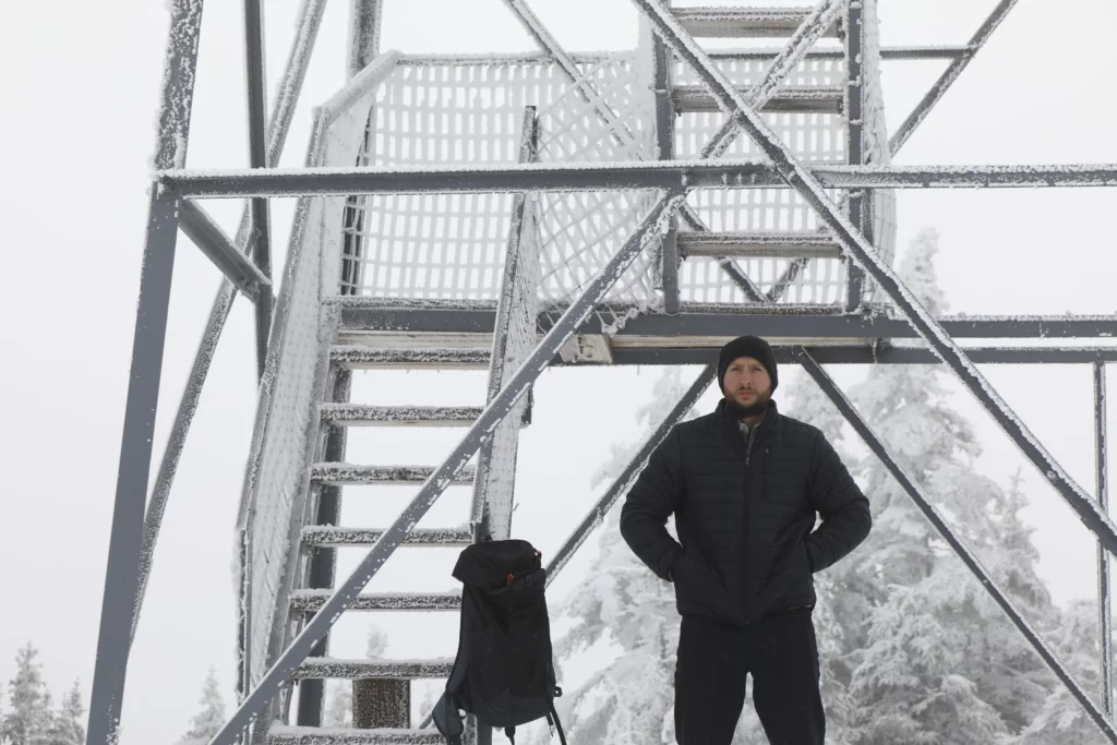 Justin throws on his down jacket before walking up the tower.